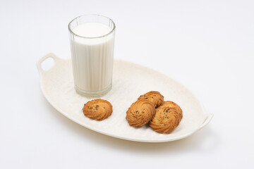 Cookies or biscuits and glass of milk on a white serving tray for breakfast or snacks, a healthy concept lifestyle with copy space for text isolated on white background