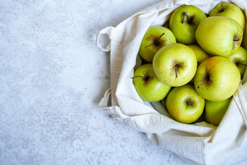 Eco-bag full of green apples on white background 