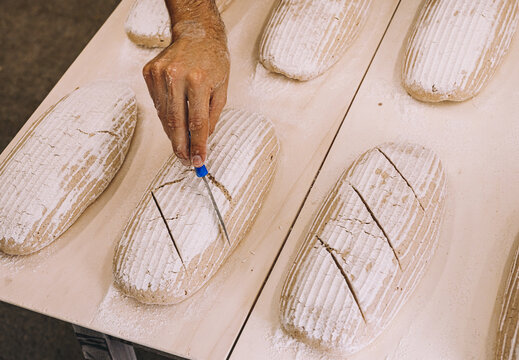 Crop Male Cook Scoring Raw Bread