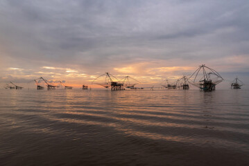 A group of giant yor and a large fishing net in the freshwater sea at dawn in Pak Pra, Phatthalung Province, Southern Thailand.