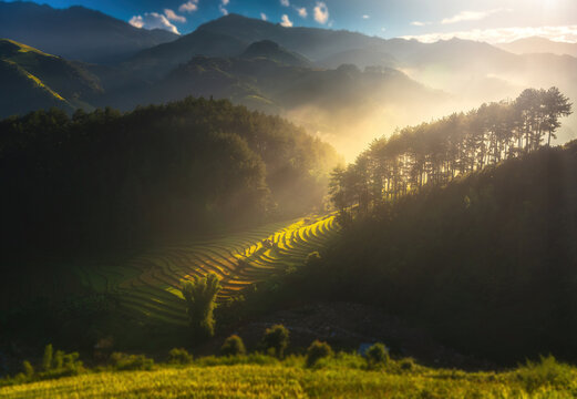 The light shines on the huts and terraced rice fields in the mountains Morning, in Southeast Asia.