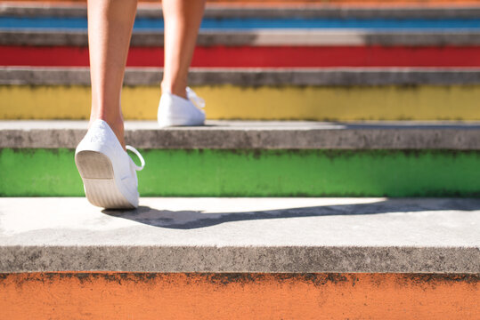 Anonymous tourist ascending bright urban staircase in sunlight