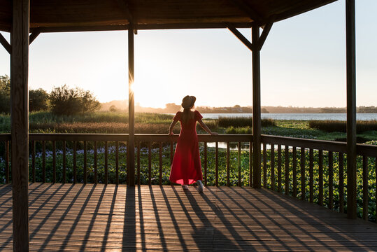 Faceless traveler admiring nature from veranda in evening