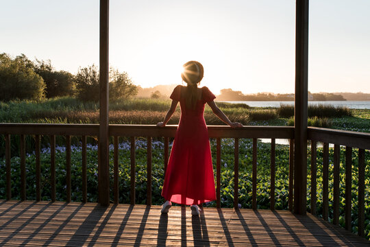 Faceless traveler admiring nature from veranda in evening