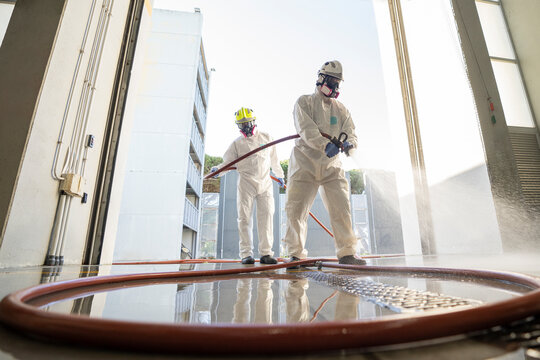Two firefighters disinfecting the interior of a building