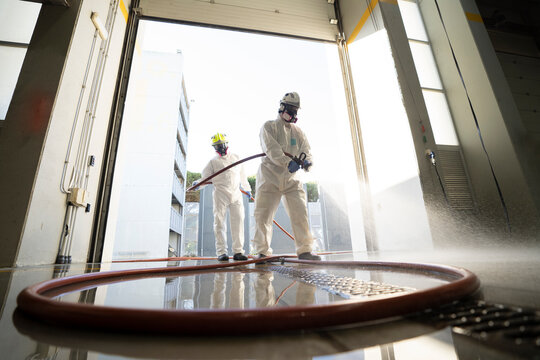 Two firefighters disinfecting the interior of a building