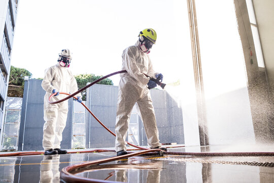 Two firefighters disinfecting the interior of a building