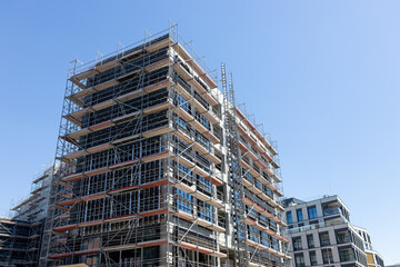 Construction site on blue sky background. High-rise building under construction. A view at a detail of a modern new apartment building
