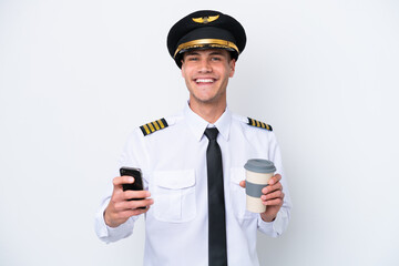 Airplane caucasian pilot isolated on white background holding coffee to take away and a mobile