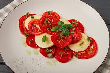 Caprese salad, Italian traditional dish, tomatoes with mozzarella cheese, basil and spices, top view, no people,