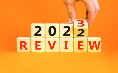 2023 review new year symbol. Businessman turns a wooden cube and changes words Review 2022 to...