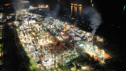 Aerial drone night shot of illuminated industrial crude oil refinery near area of Isthmus canal, Corinth, Greece