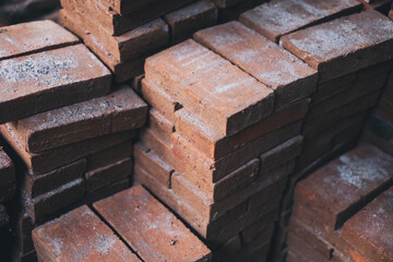 Stacks of newly made solid bricks made from clay (baked earth) used for landscaping, and other building and construction purposes. Selective focus.