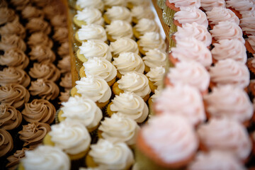 Rows of chocolate, vanilla and strawberry cupcakes at a wedding reception