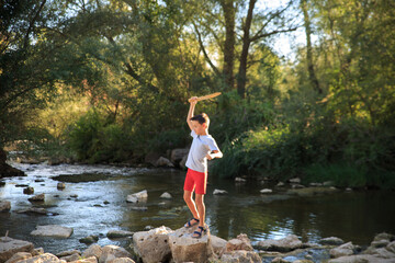 child plays in the river in summer. Children's activities in nature