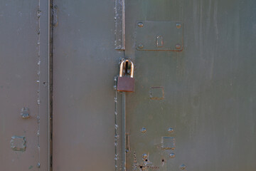 The lock on the rusty metal gate on the garage