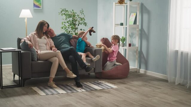 man and woman are in room with children, children happily play with toys