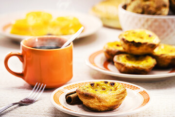Traditional Portuguese dessert of pastel de nata, and bree de lis and bread in the background, served with coffee, typical Lisbon sweets - obrazy, fototapety, plakaty