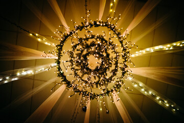 An array of sparkly lights hunt from streaming fabric on a ceiling as a chandelier