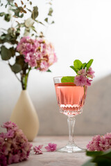 Obraz na płótnie Canvas Pink drink cocktails, liquor or gin. Pink sangria fruity wine with hydrangea pink flowers. Bright, girly background