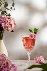 Pink drink cocktails, liquor or gin. Pink sangria fruity wine with hydrangea pink flowers. Bright, girly background