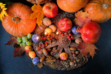 Wiccan altar for Mabon sabbat. fruits, pumpkins, candles, nuts, wheel of the year on black background. pagan, Wiccan traditions. Witchcraft, esoteric spiritual ritual. top view