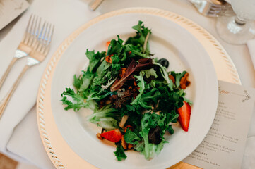 salad with strawberries on white and gold charger