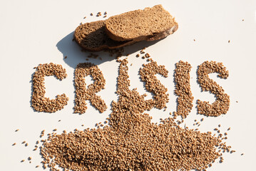 Word crisis from wheat grains and bread slices. The concept of problems with the supply of wheat and flour. Global food crisis. Top view, Flatley