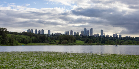 Deer Lake with Modern City Building Skyline in background. Cloudy Spring Day. Burnaby, Vancouver, British Columbia, Canada.