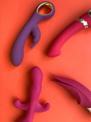 Pink sex toys. Four vibrators for red background. Useful for sex shop or adults