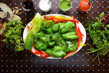 hariyali Murgh tikka or green chicken tikka boti with sauce, ketchup, mint raita and salad served in a dish isolated on table background top view of bangladesh food