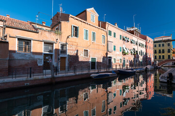 Vue typique et touristiques des canaux de Venise en Italie avec les batiments colores historiques qui se reflete dans l'eau