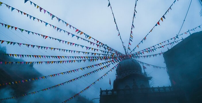 Prayer flags tied to the dome of a temple in Kasol, India.