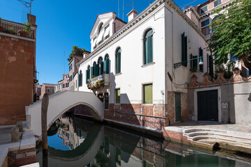 Vue d'un pont sur un canal a Venise qui se reflete dans l'eau