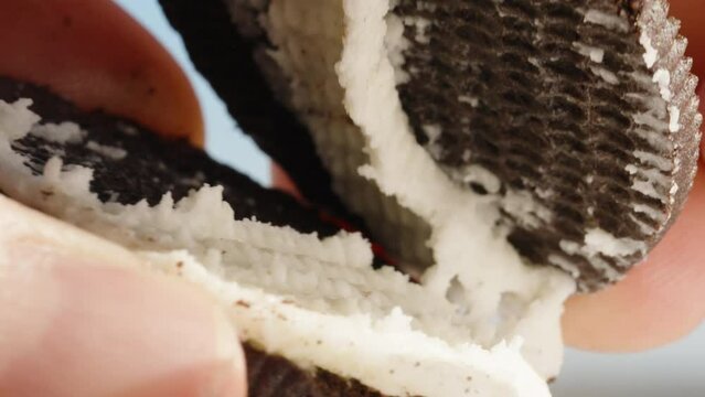 I separate the two halves of a round chocolate cookie with milk cream. Macro
