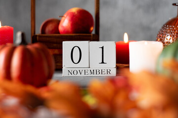 wooden calendar 1 st november. autumn decor apples candles and pumpkins