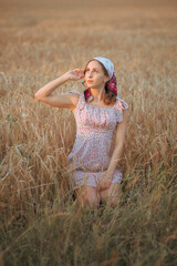 Portrait of a beautiful young woman. A woman poses in a wheat field at sunset.