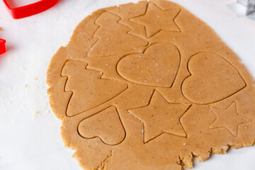 Making cookies in the shape of heart, Christmas tree, star from shortbread dough.