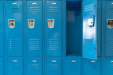 Single open empty blue metal locker along a nondescript hallway in a typical US High School.  No identifiable information included and nobody in the hall.  	 - obrazy, fototapety, plakaty