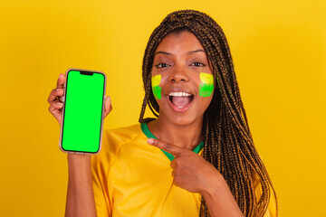 black woman young brazilian soccer fan. holding cellphone, app, smartphone. close-up photo