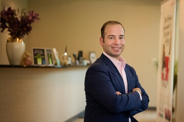 Fototapeta premium THE WOODLANDS, TEXAS - SEPTEMBER 1ST 2022: Doctor is posing in a suit for environmental portraits at his medical office The Woodlands Plastic Surgery to promote his business at Living Magazine