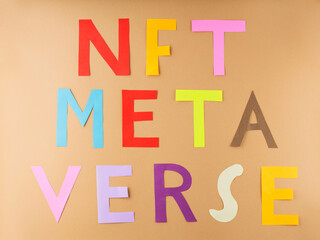 NFT METAVERSE text on a beige background. Inscription Nft Metaverse with multi-colored paper letters. Metaverse, virtual reality and blockchain technology