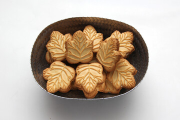 Delicious cookies filled with vanilla cream made with honey or maple syrup from Canadian trees, the traditional sweet of Canada in a gray basket on a white background