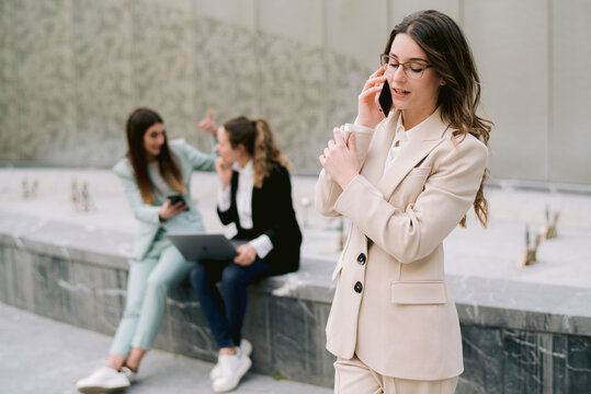 Elegant businesswoman speaking on smartphone in city - Powered by Adobe
