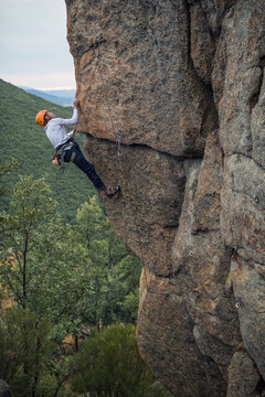 Climber in equipment climbing mountain helping with hand and leg