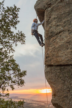 Climber in equipment climbing mountain helping with hand and leg