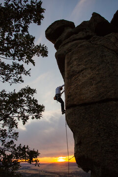 Climber in equipment climbing mountain helping with hand and leg