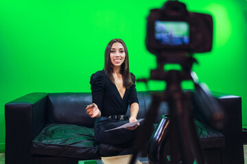 Positive woman recording video on camera in studio