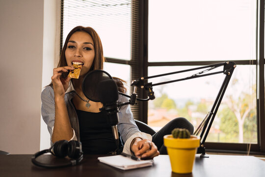Young woman eating snack at workplace