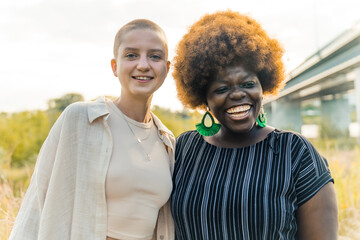 Close interracial friendship. Delighted happy mixed race girls smiling and embracing. Value of...